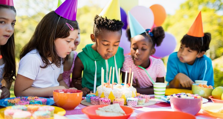 Cute children blowing together on the candle during a birthday party