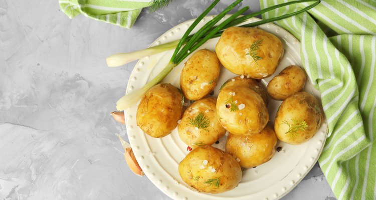 Plate with boiled potatoes on table