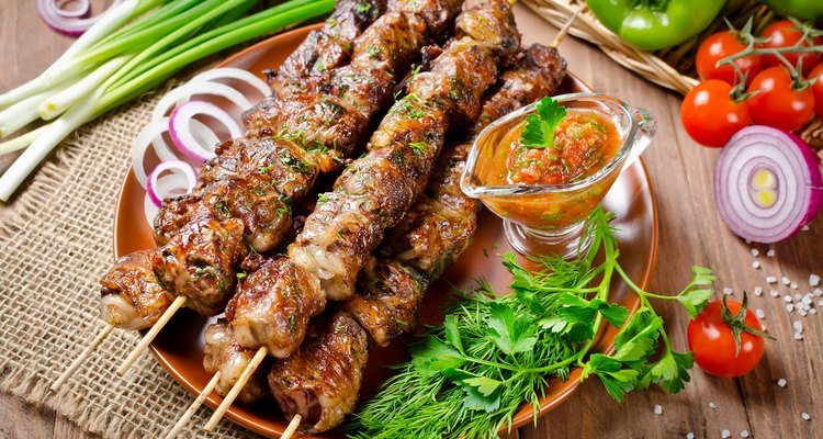 Grilled beef liver kebabs on a dark wooden background