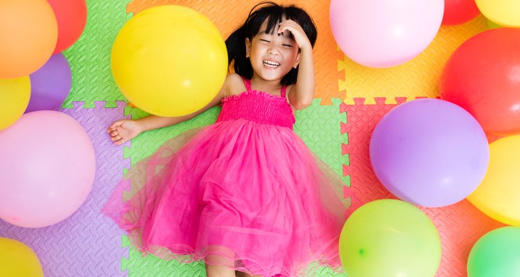 Asian Little Chinese Girl Lying on Floor amongst Balloons