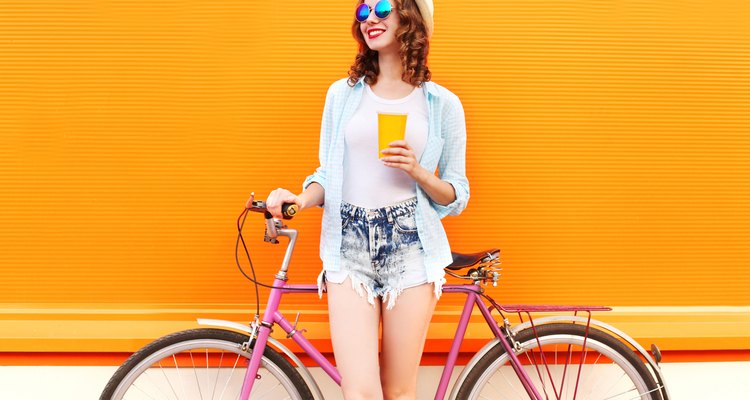 Fashion woman with coffee or juice cup and retro bicycle