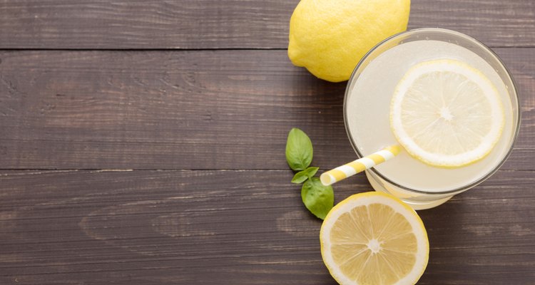 lemonade with fresh slice lemon on wooden background