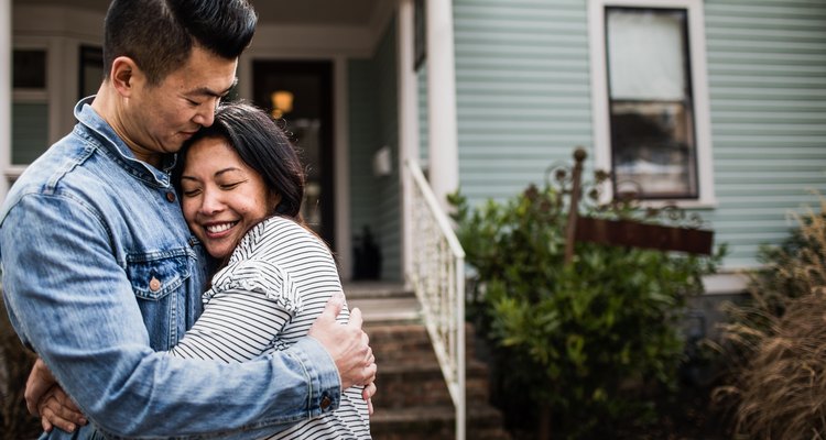 Portrait of young couple in front of home