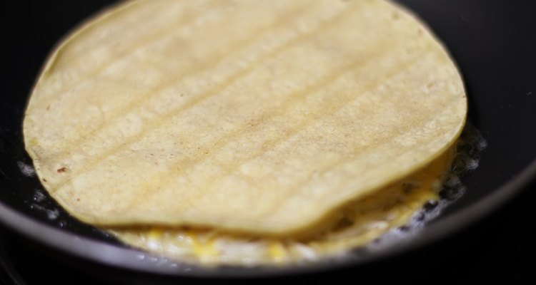 Cheese melting between two tortilla layers in a skillet.
