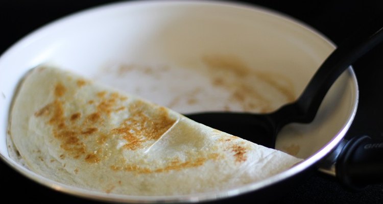 Folded quesadilla in a skillet.