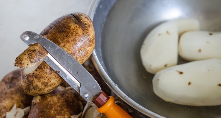 Coloque as batatas descascadas em uma tigela com água fria e sal