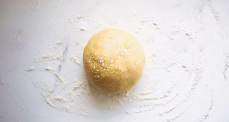 Dough placed on a lightly floured surface and kneaded to form a smooth ball.