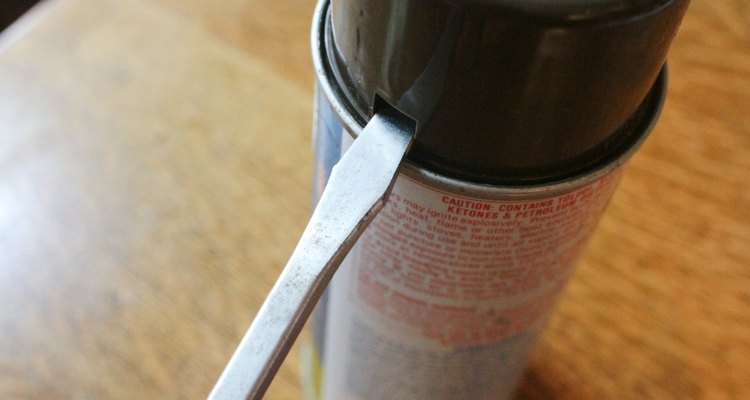Coloque a ponta da chave de fenda no buraco quadrado da tampa e aponte-a para a parte superior da lata