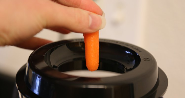 Presiona las zanahorias con la varilla.