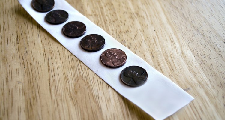 Cole moedas em um pedaço de fita adesiva