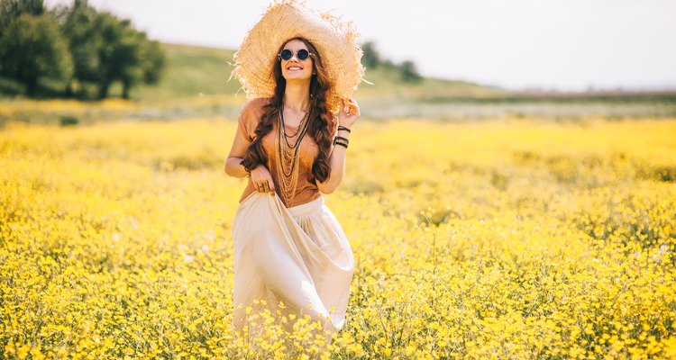Hippy woman frolicking in wild flower field.