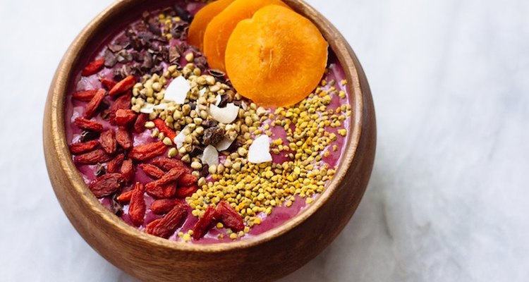 Acai bowl topped with goji berries, raw cocoa powder and shredded coconut.