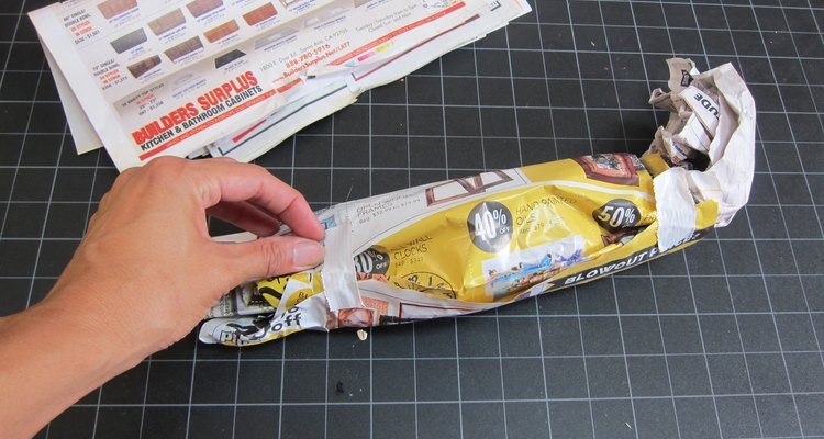 Haz un rollo de papel periódico.