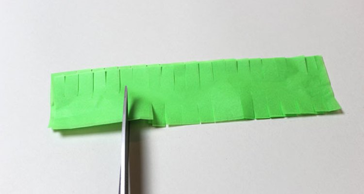 Corta algunas aberturas a lo largo de las tiras de papel de seda.