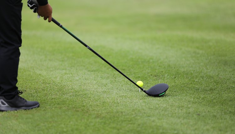 Golf ball on green grass ready to be struck on grass background