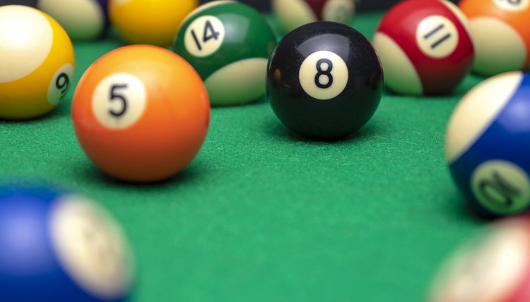 BILLIARD BALLS ON A POOL TABLE. THE EIGHT BLACK ONE IN FOCUS. LEISURE CONCEPT.