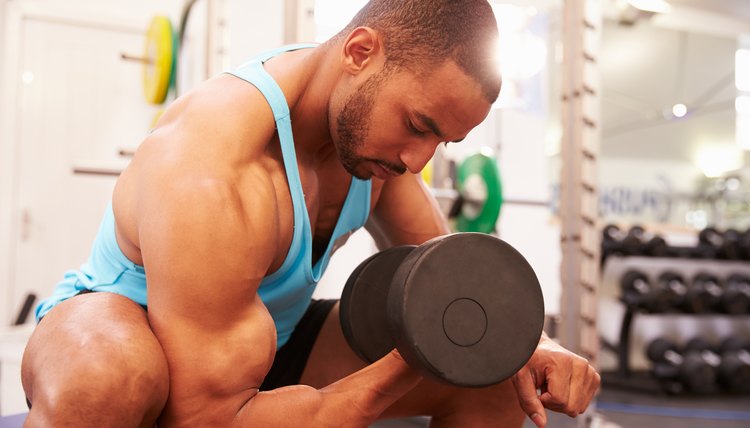 Man exercising with dumbbells at a gym, horizontal shot