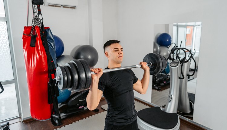 Young Man Lifting Weights At The Gym