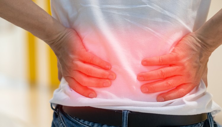 Man's hands on his back with red spot as suffering on backache. Male person sick from lower back pain from Herniated or slipped discs,Degenerative, sacroiliac joint, spinal stenosis, Pancreatic Cancer