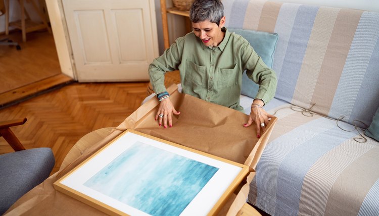Mujer desempaca pintura que compra en línea.