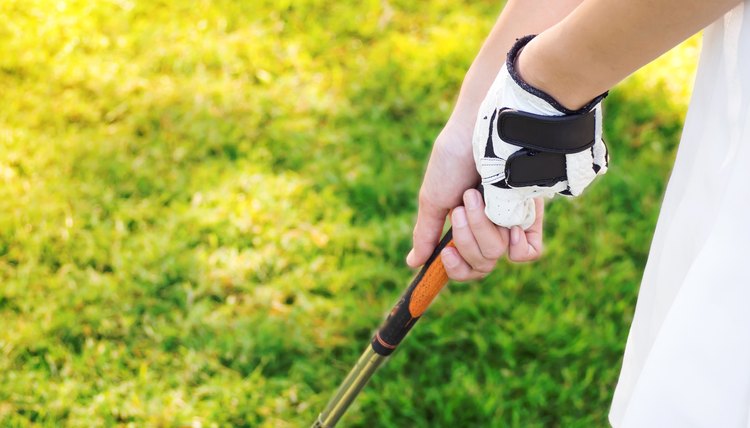 Closeup woman hand gripping golf club. Sport background with copy space.