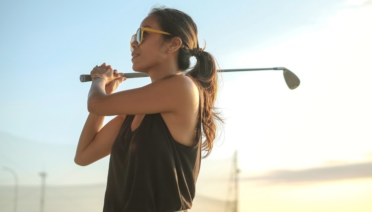 Confident Asian Woman Swinging Golf Club