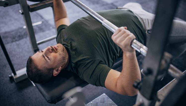 Man doing bench press in gym