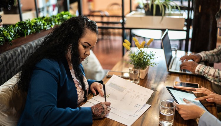 Mujer sentada en una mesa llenando un formulario.