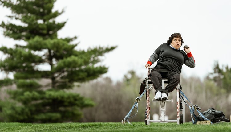 Senior disabled Latin lady practising shot put