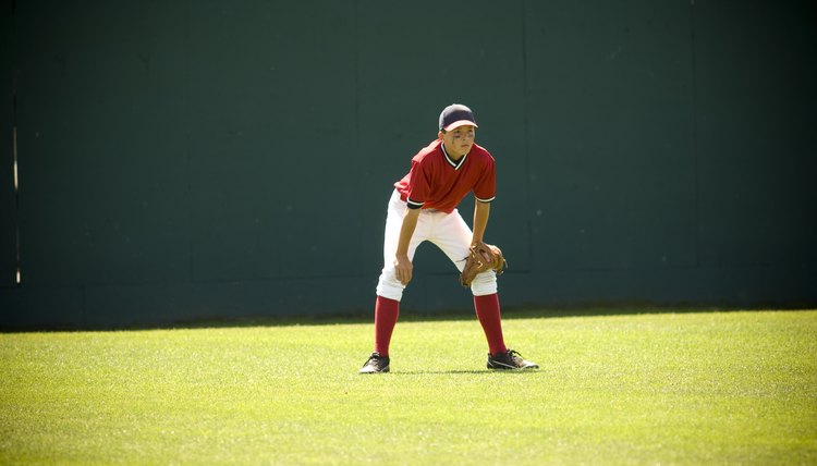 Boy in ready position in the outfield of a baseball field