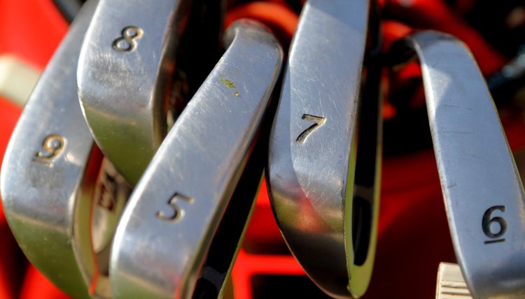 Closeup of Golf clubs with numbers in golf bag.
