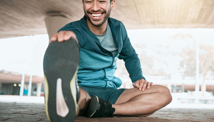 Shot of a young man stretching before a run