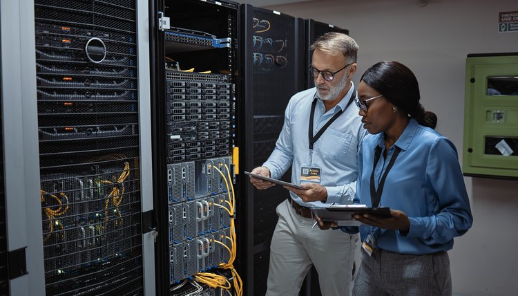Dos técnicos en computación revisando los servidores en una empresa.