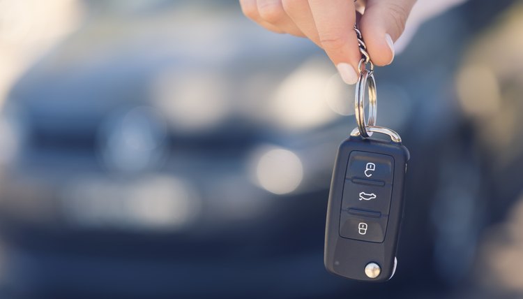 Una mano de una persona sostiene unas llaves de un auto.