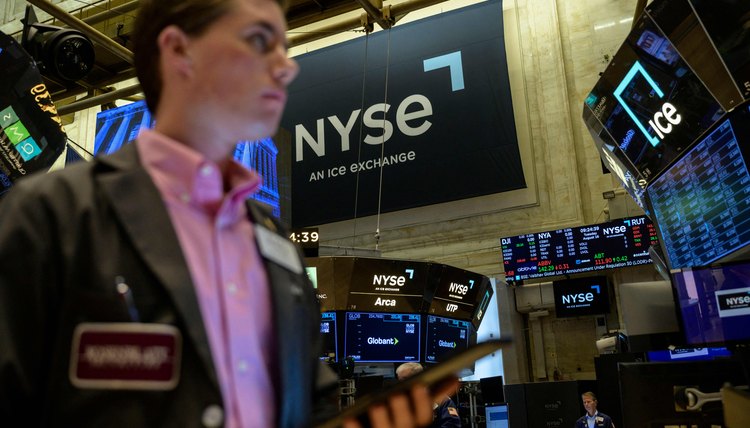 Hombre en el NYSE viendo un monitor con información de acciones.