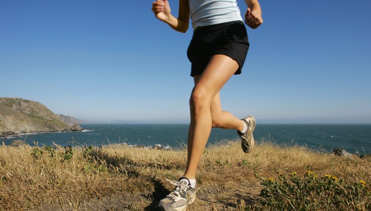 Woman running along coastline,  California,  USA