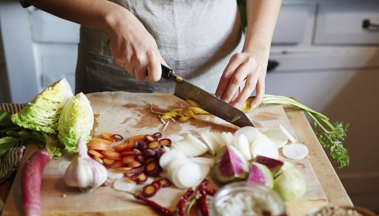 Woman cooking in kitchen with ingredients around her