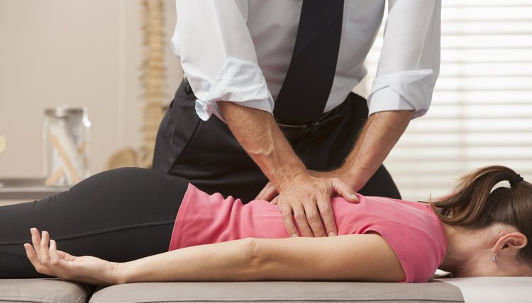 USA, Utah, Orem, Woman lying on her front side getting adjusted by chiropractor