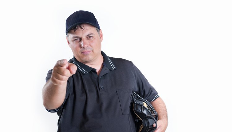 Professional baseball umpire in uniform on white background