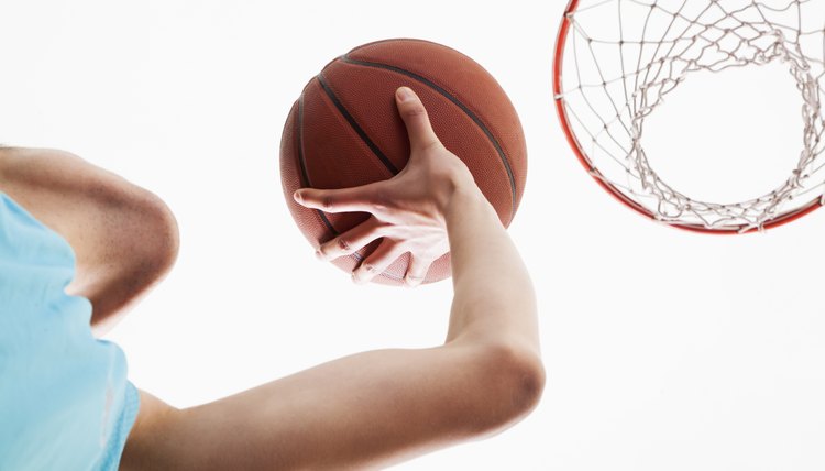 Man attempting to through basketball in to the basket