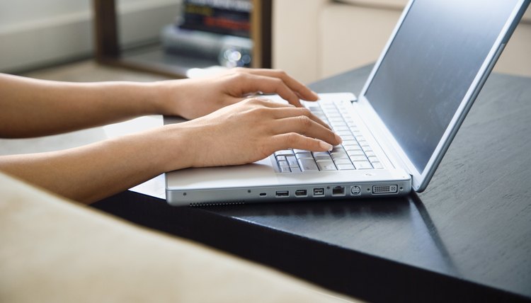 Hands typing on laptop