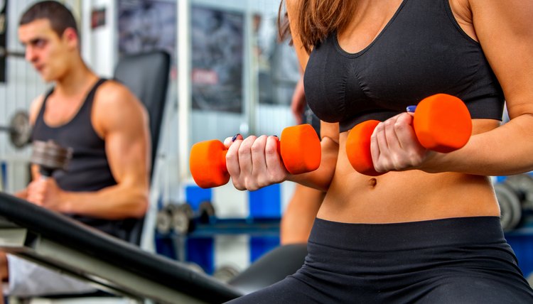 Group of people  working with dumbbells  at gym