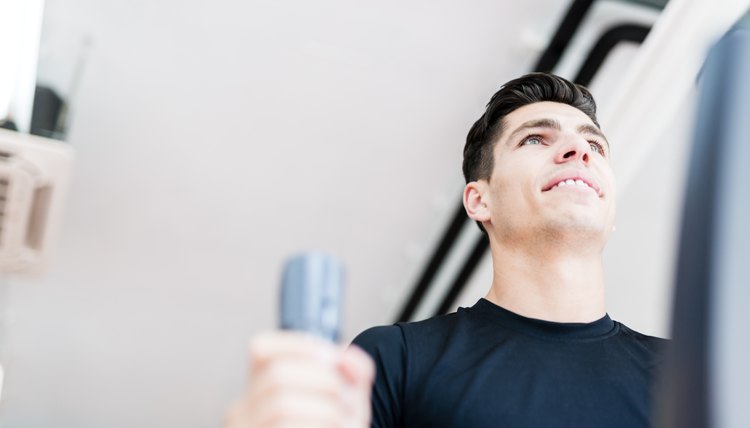 Young fit male working out on an elliptical trainer