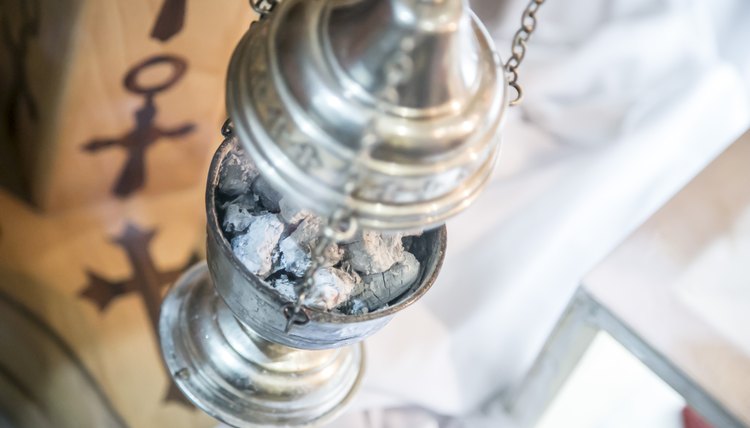 Incense smoke cascades from a thurible.