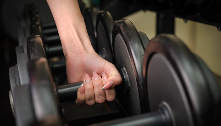 Female hand holding dumbbell