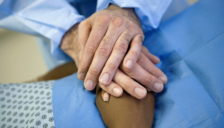 Healthcare worker holding hands with patient
