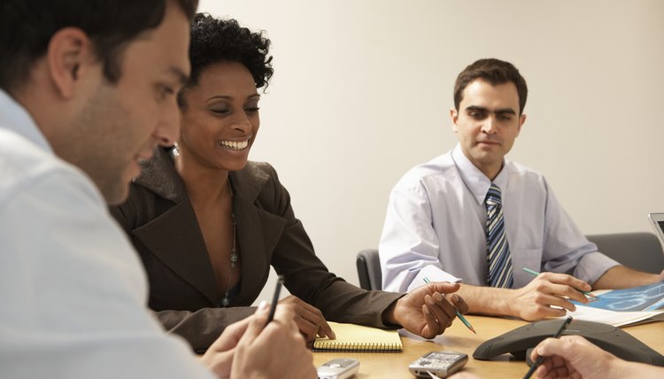 A group of professionals conducting a business meeting at a conference table.