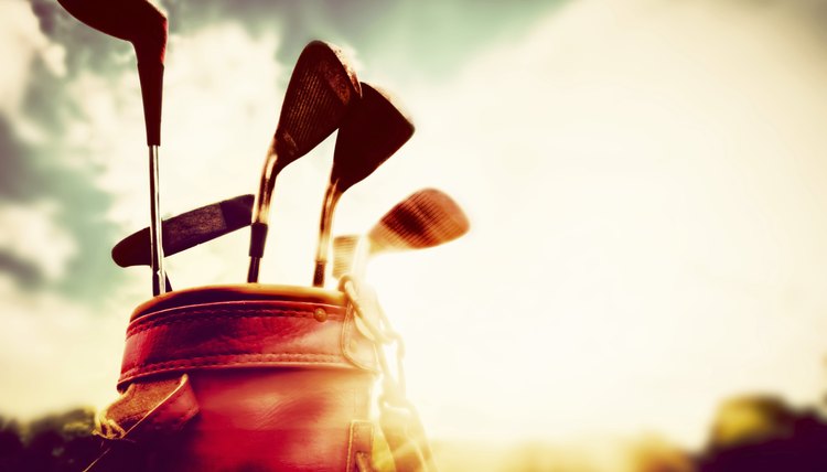 Golf clubs in a leather baggage vintage style at sunset