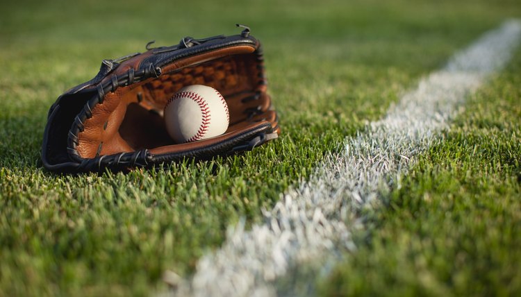 Baseball mitt and ball in grass with selective focus