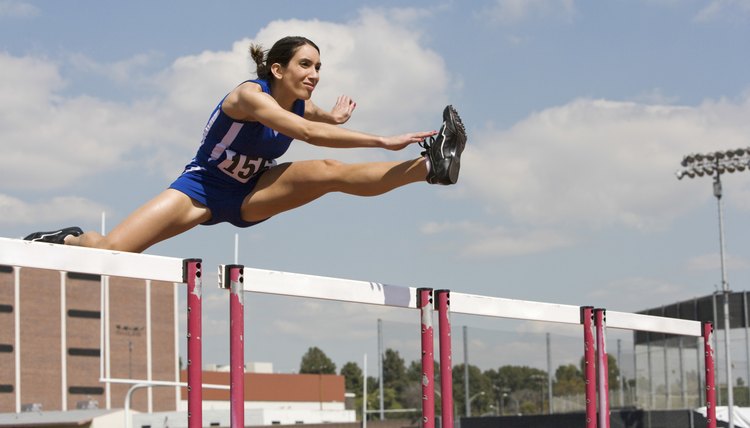 Female Athlete Jumping Over A Hurdles